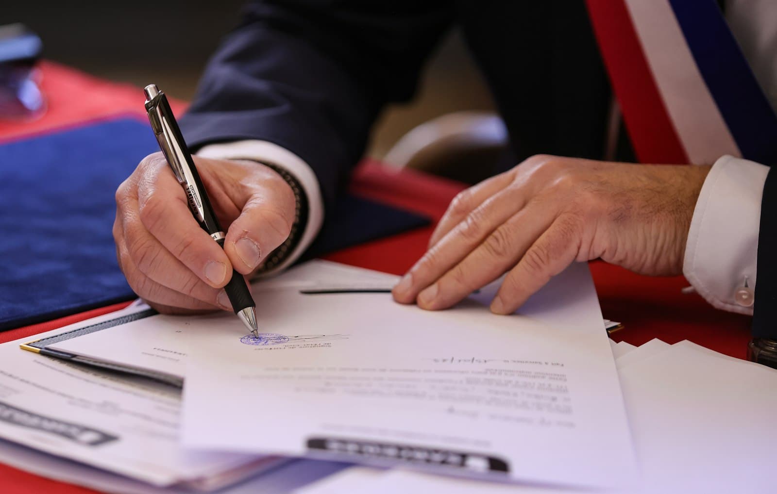 Close-up of hands signing a printed document