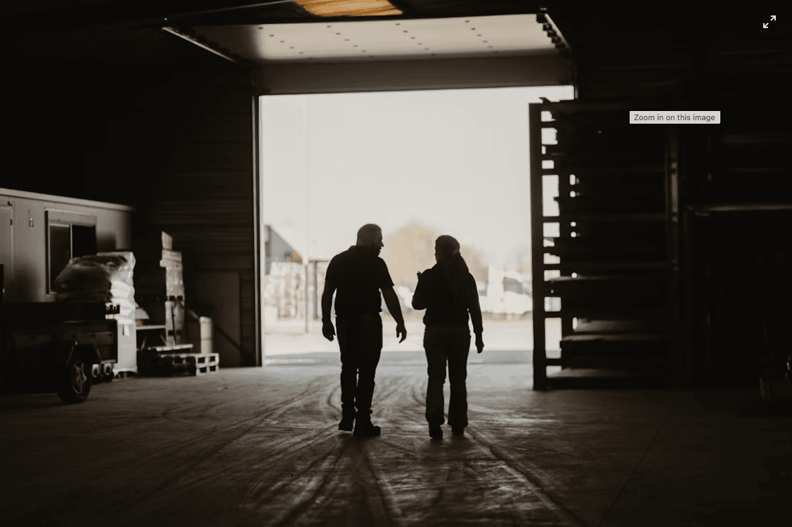 A man and woman waking into a garage