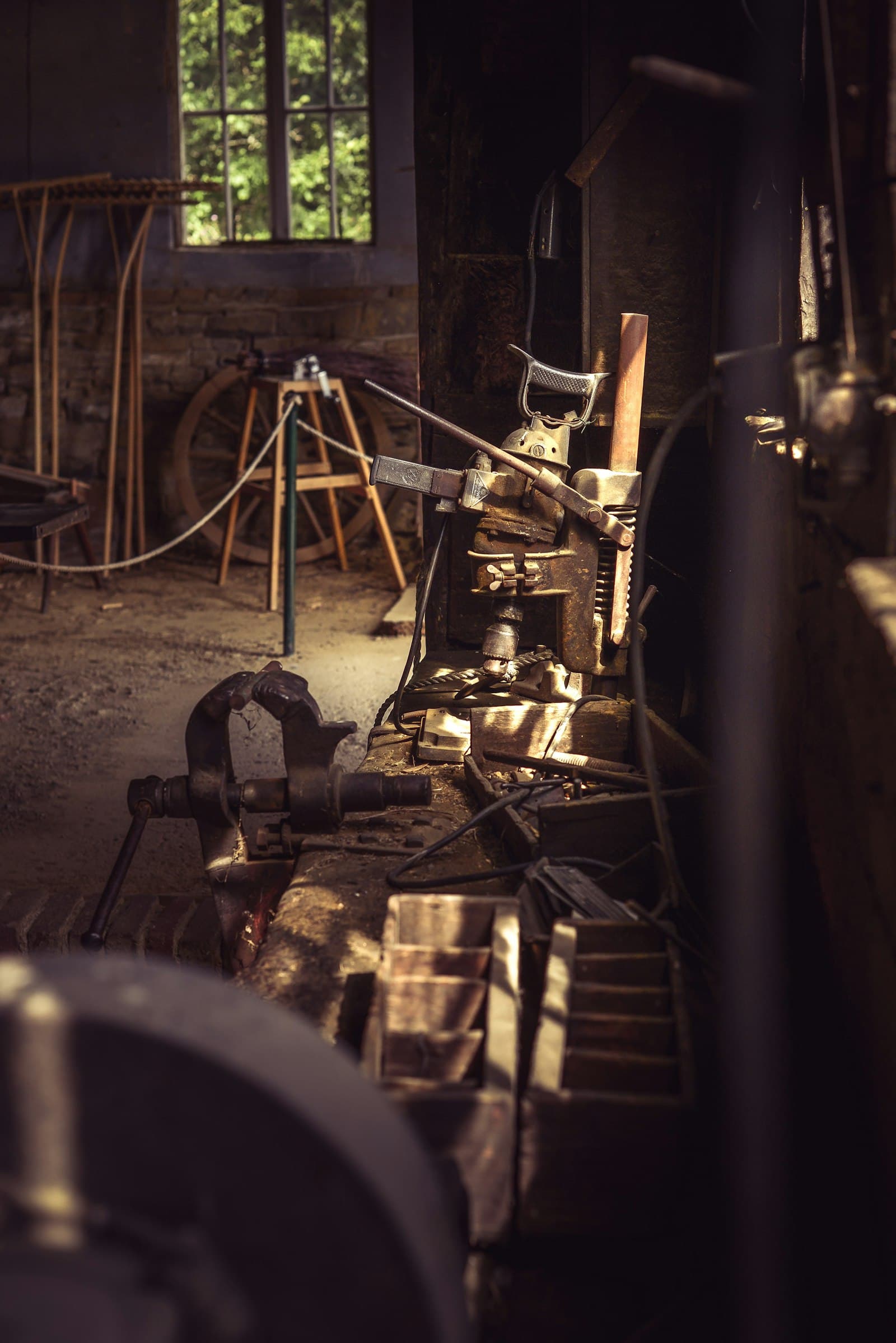 A workshop bench of tools and part-finished work, nobody in the room